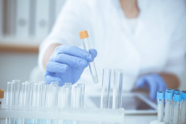 Koruyucu gözlüklü profesyonel kadın bilim adamının laboratuarda reaktörlerle deney yapması. Tıp ve araştırma konsepti