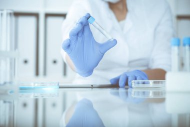 Koruyucu gözlüklü profesyonel kadın bilim adamının laboratuarda reaktörlerle deney yapması. Tıp ve araştırma konsepti