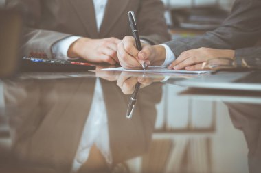 İki kadın muhasebeci mali durumu kontrol ediyor ya da vergi formları için hesap makinesinden para sayıyor, eller yakın çekim. Milli Gelir İdaresi müfettişi mali belgeleri kontrol ediyor. Planlama bütçesi ve