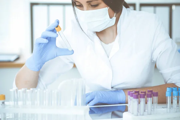 Close-up de cientista profissional feminino em óculos de proteção fazendo experiência com reagentes em laboratório. Medicina e conceito de pesquisa — Fotografia de Stock