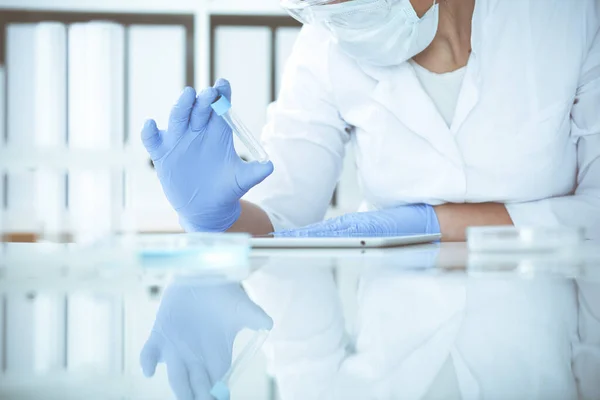 Close-up de cientista profissional feminino em óculos de proteção fazendo experiência com reagentes em laboratório. Medicina e conceito de pesquisa — Fotografia de Stock