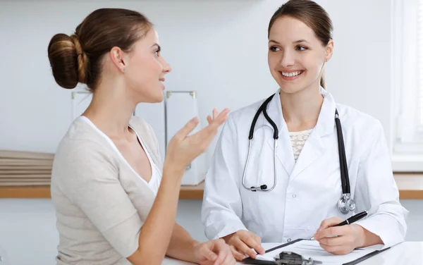 Médecin et patient sont assis et discutent des résultats des examens de santé dans le bureau de la clinique. Soins de santé, médecine et bonnes nouvelles concepts — Photo