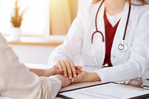 Hands of unknown woman-doctor reassuring her female patient in sunny room, close-up — Stock Photo, Image