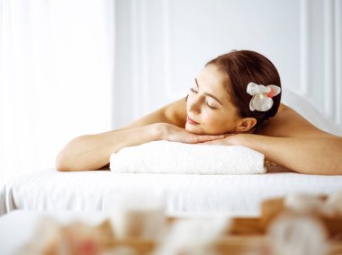 Güzel esmer kadın gözleri kapalı sırt masajından hoşlanıyor. Spa ve tıp konsepti