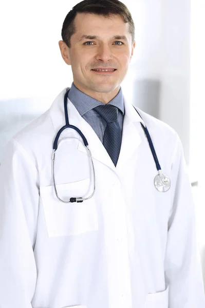 Arzt lächelt fröhlich in die Kamera. Perfekte medizinische Versorgung in der Klinik. Glückliche Zukunft in Medizin und Gesundheitswesen — Stockfoto