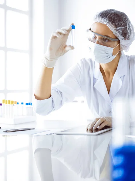 Cientista profissional em óculos de proteção pesquisando tubo com reagentes em laboratório. Conceitos de medicina e pesquisa científica — Fotografia de Stock