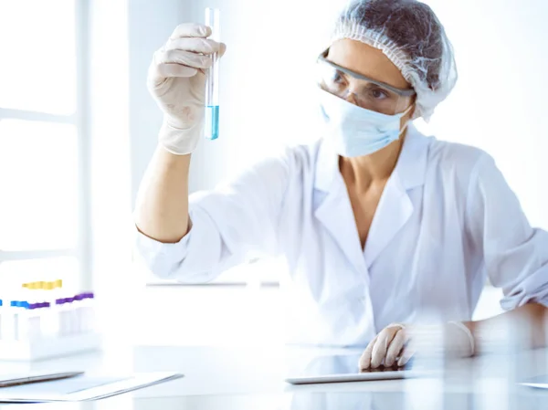 Cientista profissional em óculos de proteção pesquisando tubo com reagentes em laboratório. Conceitos de medicina e pesquisa científica — Fotografia de Stock