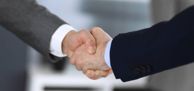 İş adamları toplantıdan ya da pazarlıktan sonra iş arkadaşlarıyla el sıkışıyorlar. Yakın plan. Modern ofisteki bir grup tanınmamış iş adamı ve kadın. Takım çalışması, ortaklık ve tokalaşma