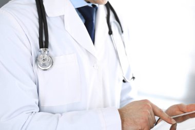 Doktor, ağ araştırması ya da sanal hastalık tedavisi için tablet bilgisayar kullanıyor. Eller yakın çekim. Klinikte mükemmel bir tıbbi hizmet. Modern tıp, tıbbi veri ve sağlık hizmetleri kavramları. Ayarlanmış