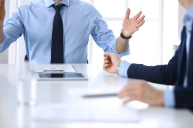 Tablet bilgisayar kullanan iki bilinmeyen işadamı ya da ortak modern ofiste görüşülen sorular, yakın çekim. Pazarlık yapan ya da beyin fırtınası yapan bir grup yönetici. Takım çalışması, ortaklık ve