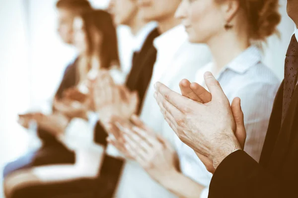 Business people clapping and applause at meeting or conference, close-up of hands. Group of unknown businessmen and women in modern white office. Success teamwork or corporate coaching concept — Stock Photo, Image