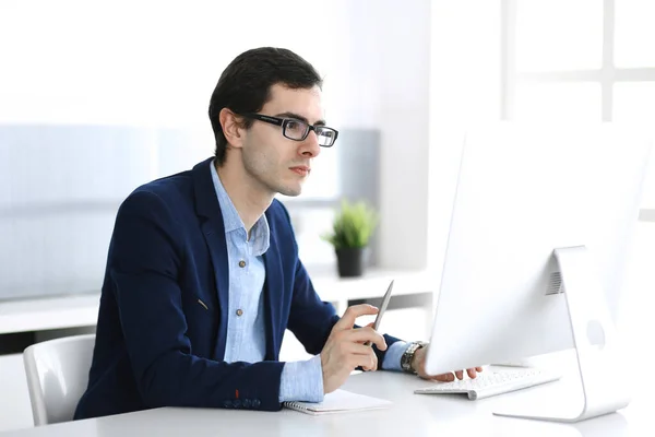 Бизнесмен, работающий с компьютером в современном офисе. Фото мужчины-предпринимателя или менеджера компании на рабочем месте. Концепция бизнеса — стоковое фото