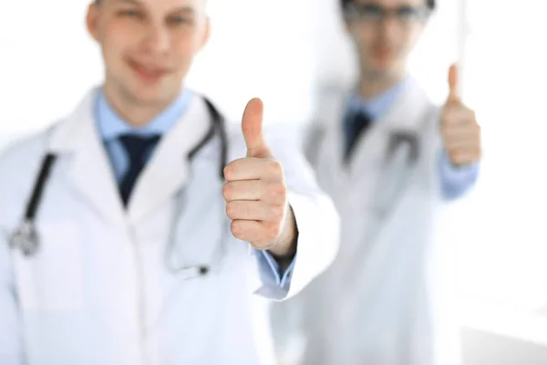 Doktor stoi prosto z kolegą i pokazuje kciuki do góry. Grupa lekarzy. Doskonała opieka medyczna w klinice. Medycyna i koncepcje opieki zdrowotnej. Obrazek naświetlony — Zdjęcie stockowe