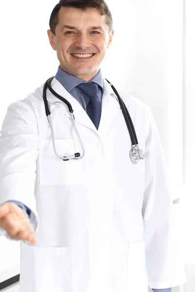 Doutor homem alegre sorrindo para a câmera, ajudando a mão. Serviço médico perfeito na clínica. Futuro feliz na medicina e na saúde — Fotografia de Stock