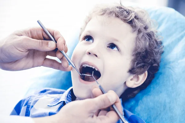 Läkare och tålmodigt barn. Pojken får tänderna undersökta hos tandläkaren. Medicin, hälsovård och stomatologi — Stockfoto