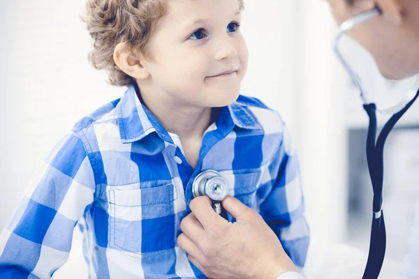 Arzt und geduldiges Kind. Arzt untersucht kleinen Jungen. Regelmäßiger Arztbesuch in der Klinik. Medizin und Gesundheitskonzept — Stockfoto