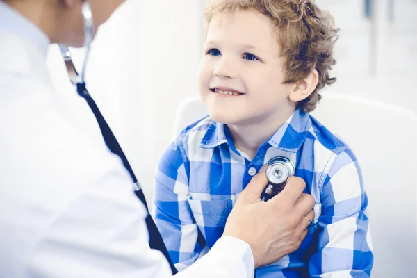 의사 이 자인 내심있는 아이. 의사가 어린 소년을 진찰하고 있다. 정기적으로 진료소를 방문한다. 의학 과 건강 관리 개념 — 스톡 사진