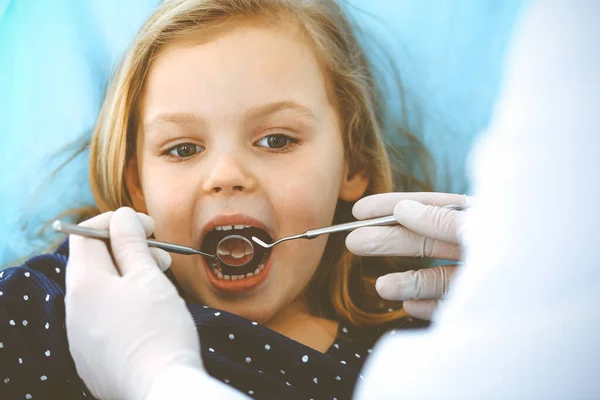 Kislány ül a fogorvosi székben nyitott szájjal orális ellenőrzés során, miközben az orvos. Fogorvosi rendelőbe megyek. Orvosi fogalom. Tonizált fénykép — Stock Fotó