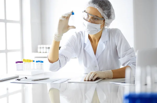 实验室内带试剂的防护眼镜研究管的专业女科学家。医药和研究的概念 — 图库照片