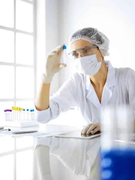 Cientista profissional em óculos de proteção pesquisando tubo com reagentes em laboratório. Conceitos de medicina e pesquisa — Fotografia de Stock