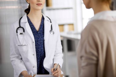 Doktor ve hasta klinikte otururken sağlık muayenesini tartışıyorlar. Hastanede mükemmel bir tıbbi hizmet. Tıp konsepti