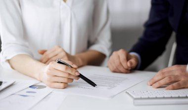 Bilinmeyen iş adamı ve kadın ofiste sözleşmeyi tartışıyorlar. Yakın çekim. İş adamları ya da avukatlar toplantıda birlikte çalışıyorlar. Takım çalışması ve ortaklık