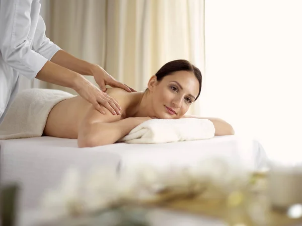 Ganska brunett kvinna njuter av proceduren med ryggmassage i spa salong. Skönhetsbegreppet — Stockfoto