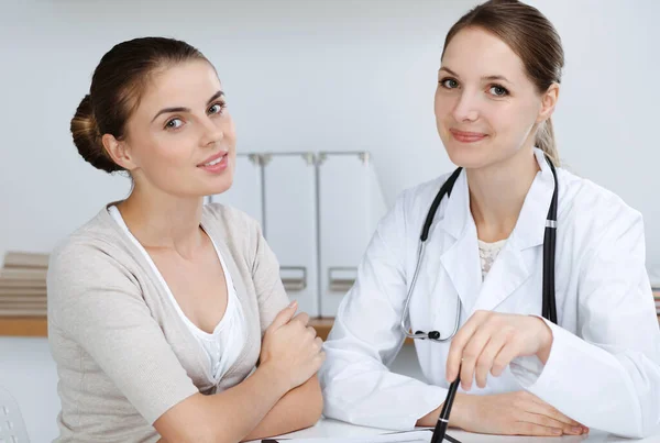 Médecin et patient sont assis et discutent des résultats des examens de santé dans le bureau de la clinique. Soins de santé, médecine et bonnes nouvelles concepts — Photo