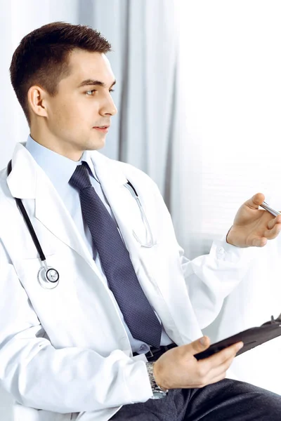 Γιατρός άνθρωπος συμπληρώνοντας ιατρική φόρμα στο πρόχειρο. Υγειονομική περίθαλψη, ασφάλιση ιατρικής και υπηρεσίες ασθενούς — Φωτογραφία Αρχείου