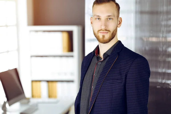 Homem de negócios adulto amigável de barba vermelha olhando para a câmera. Imagem de negócios ou retrato em escritório ensolarado — Fotografia de Stock