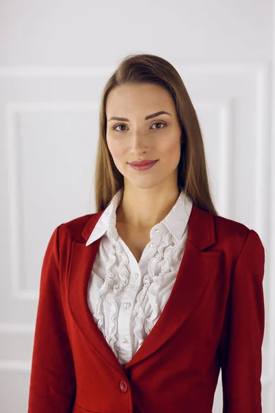 Business woman in red standing at modern office. Headshot of a young female entrepreneur — Stock Photo, Image