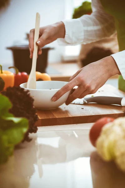 Mãos humanas desconhecidas a cozinhar na cozinha. A mulher está ocupada com salada de legumes. Refeição saudável e conceito de comida vegetariana — Fotografia de Stock