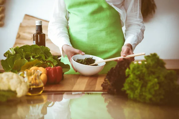 Onbekende mensenhanden die koken in de keuken. Vrouw is bezig met groentesalade. Gezonde maaltijd en vegetarisch voedselconcept — Stockfoto