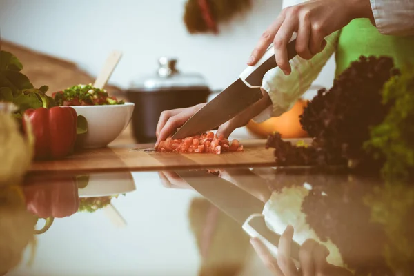 모르는 인간 손으로 부엌에서 요리하고 있어. 빨간 토마토를 썰고 있는 여자. 건강에 좋은 식사와 채식 식품의 개념 — 스톡 사진