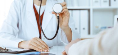 Elinde steteskop olan kimliği belirsiz bir kadın doktor. Doktor bir hastayı muayene etmeye hazır, yakın çekim. Tıp konsepti