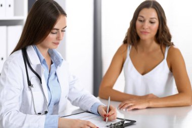 Doktor ve mutlu hasta masada otururken konuşuyor. Doktor ya da terapist sağlıklı yaşam tarzını tartışıyor. Sağlık, ilaç ve hasta hizmetleri kavramı