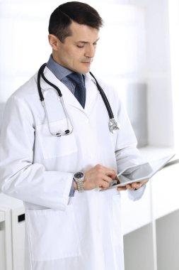 Doktor, ağ araştırması ya da sanal hastalık tedavisi için tablet bilgisayar kullanıyor. Klinikte mükemmel bir tıbbi hizmet. Modern tıp, tıbbi veriler ve sağlık hizmetleri kavramları için mutlu bir gelecek.