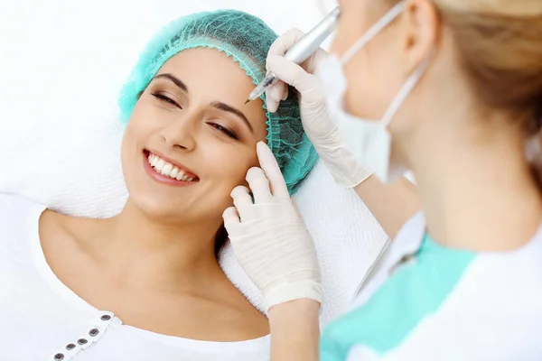 Professionele schoonheidsspecialiste die wenkbrauwtatoeage doet op vrouwengezicht. Permanente make-up in schoonheidssalon, close-up. Cosmetologische behandeling — Stockfoto