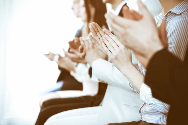Az üzletemberek tapsolnak és tapsolnak a találkozón vagy konferencián, közelről. Ismeretlen üzletemberek és nők csoportja a modern fehér irodában. Sikeres csapatmunka vagy vállalati coaching koncepció — Stock Fotó