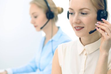 Parlak ve güneşli çağrı merkezi. Bir grup sarışın kadın iş yerinde. Ofis ve iş konsepti.