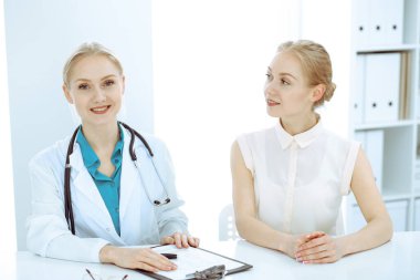 Doktor ve hasta masada oturuyor. Doktor ya da terapist teşhis koyuyor. Sağlık, ilaç ve hasta hizmetleri kavramı.