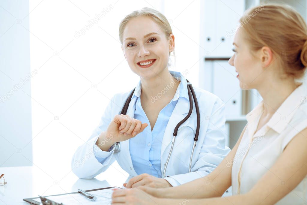 Doctor and patient sitting at the desk. The physician or therapist makes a diagnosis. Health care, medicine and patient service concept.