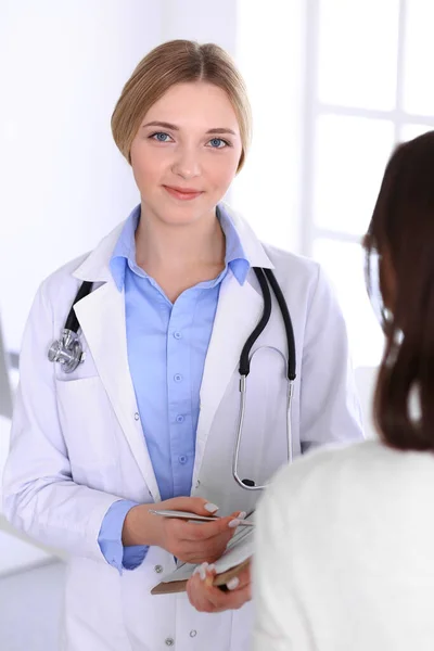 Young woman doctor and patient at medical examination at hospital office. Blue color blouse of therapist looks good. Medicine and healthcare concept — Stock Photo, Image