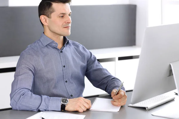 Бизнесмен, работающий с компьютером в современном офисе. Фото мужчины-предпринимателя или директора компании на рабочем месте. Концепция бизнеса — стоковое фото