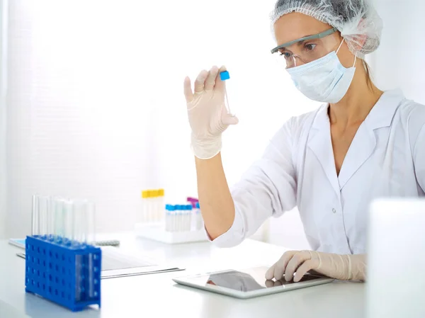 Cientista profissional em óculos de proteção pesquisando tubo com reagentes em laboratório. Conceitos de medicina e pesquisa — Fotografia de Stock
