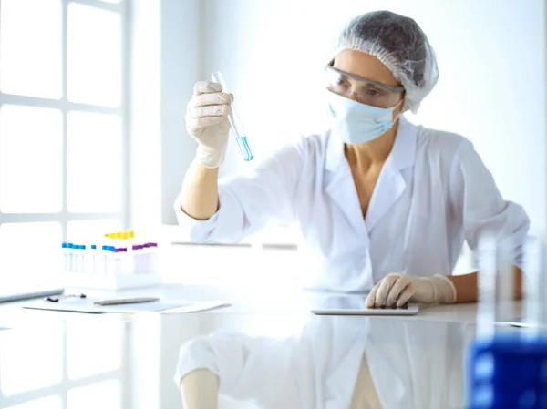 Cientista profissional em óculos de proteção pesquisando tubo com reagentes em laboratório. Conceitos de medicina e pesquisa — Fotografia de Stock