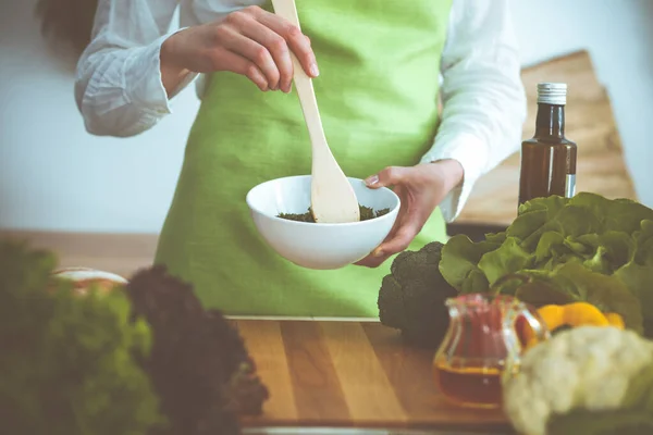 Mãos humanas desconhecidas a cozinhar na cozinha. A mulher está ocupada com salada de legumes. Refeição saudável e conceito de comida vegetariana — Fotografia de Stock