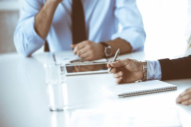 Bir grup tanınmamış iş adamı modern ofiste sorular sorup el ele tutuşuyorlar. Pazarlık yapan ya da beyin fırtınası yapan yöneticiler. Takım çalışması, ortaklık ve iş konsepti.