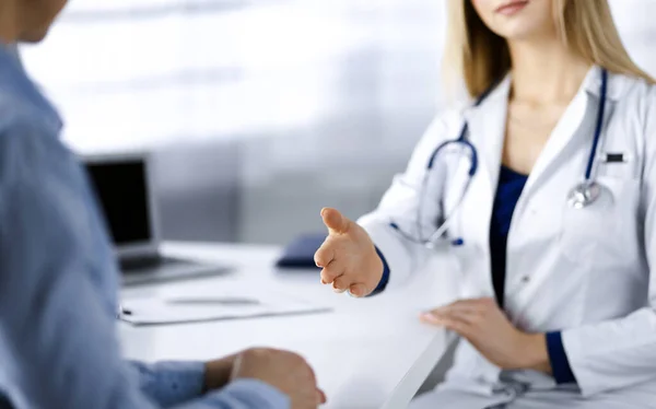 Mulher-médico desconhecida está conversando com seu paciente, enquanto eles estão sentados juntos no armário em uma clínica. Médica com estetoscópio no trabalho, close-up. Serviço médico perfeito em um hospital — Fotografia de Stock