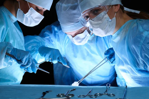 En grupp kirurger med skyddsmasker som utför operationer. Medicinskt koncept — Stockfoto